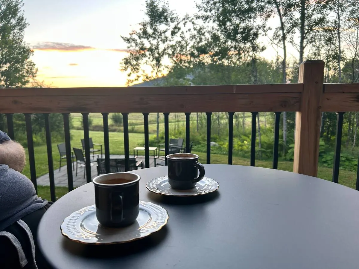 Two cups of coffee on the deck table at sunrise