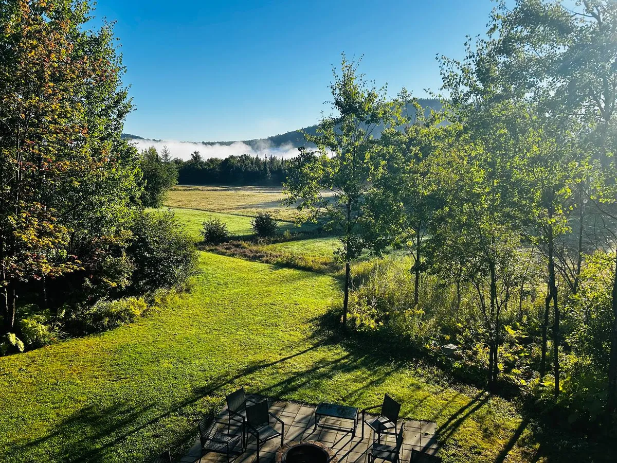Morning mist over the meadow and the hills, seen from the deck